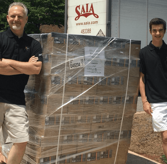 Elijah and Bret Morey with a case of Elijah's Xtreme hot sauce